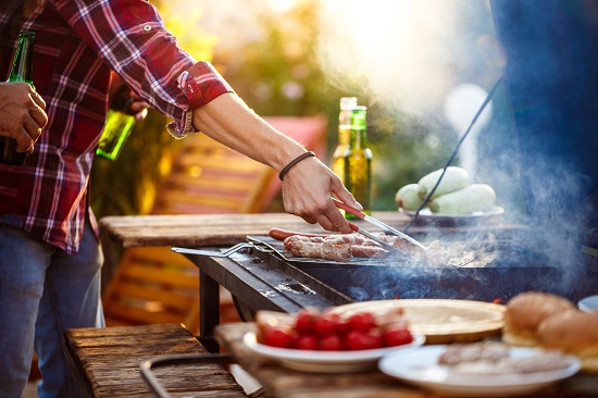 Homens jovens assando churrasco na grelha